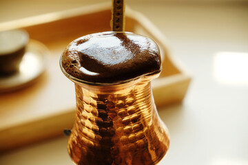 Rising coffee in copper cezve close-up. Turkish coffee