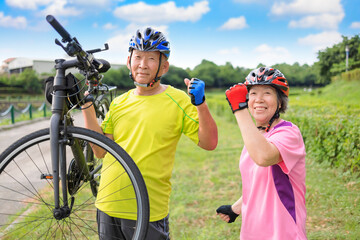 Wall Mural - Happy healthy senior couple exercising with bicycles