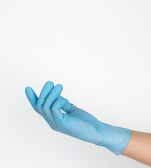 Wall Mural - Doctor's hand in a blue medical glove holds an object on a white background. Copy space, hold any object