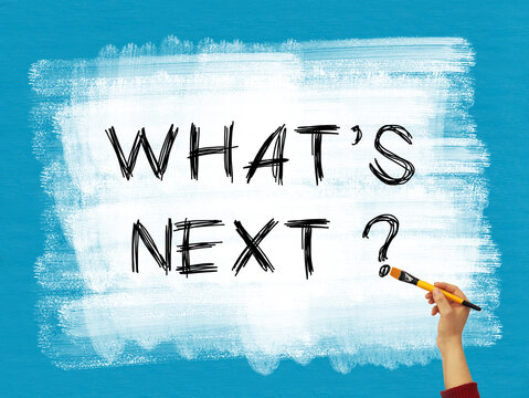 What's next concept with hand holding brush on a white painted background on blue