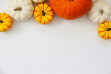 Bunch Of Classic Orange, Hooligan And Baby Boo Pumpkins On Bright Background As A Symbol Of Autumnal Holidays With A Lot Of Copy Space For Text. Close Up.