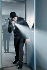 Wall Mural - Security guard with flashlight at door in empty parking garage