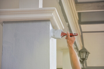 man hand painted a house pillar with brush