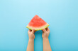 © fotoduets - Baby hands holding red slice of watermelon on light blue table background. Pastel color. Closeup. Point of view shot. Top down view.