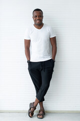 African American ethnicity man wears white t-shirt and hands in with his hands in his pocket, on white background, happy confident black guy posing for full body