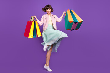 Canvas Print - Full size photo of cheerful young woman hold hands bags shopper smile isolated on purple color background