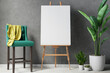 Blank canvas on wooden easel with plant