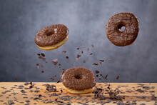 Doughnut Trio Falling On Table Together With Chocolate Bits In A Studio Shot