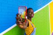 © ADDICTIVE STOCK - Smiling black woman taking selfie on smartphone