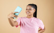 © PintoArt - pretty young african woman making selfie with her smartphone beige background