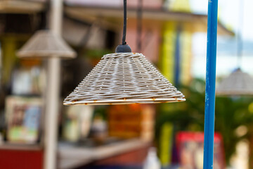 Sticker - Closeup shot of a lamp with brown wicker covering on the outside of a street