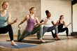 © Drazen - Young sportswomen do Yoga relaxation exercises at group training in health club.