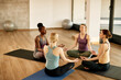 © Drazen - Group of athletic women meditate in lotus position during Yoga class at health club.