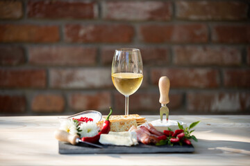 Poster - Glass of wine with bread, cheese, and peppers on a dining board