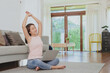 © interstid - Happy Asian woman stretching after using laptop working at home