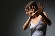 © Pixel-Shot - Scared young woman on dark background. Concept of harassment