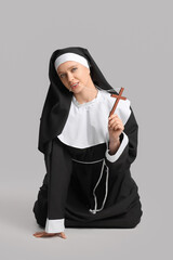 Wall Mural - Sexy nun with cross on grey background