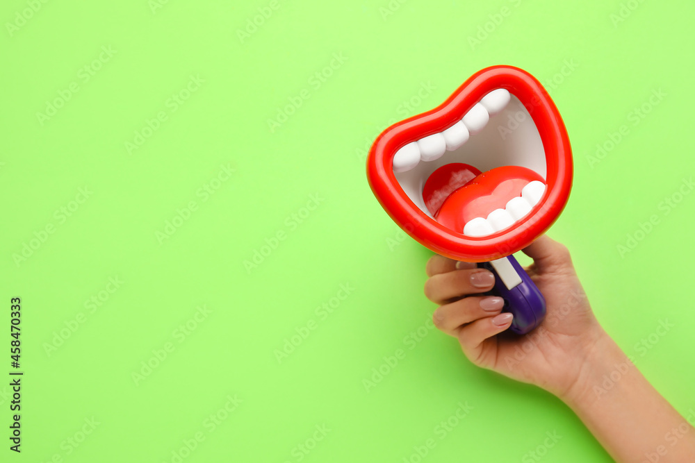 Woman with toy megaphone on green background