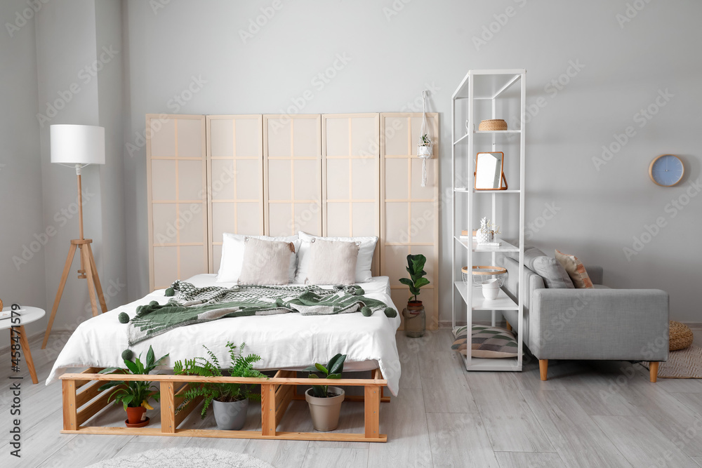 Interior of stylish bedroom with folding screen