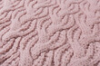 © aneduard - chunky knit fabric with large diagonal patterns, pastel pink, selective focus, macro