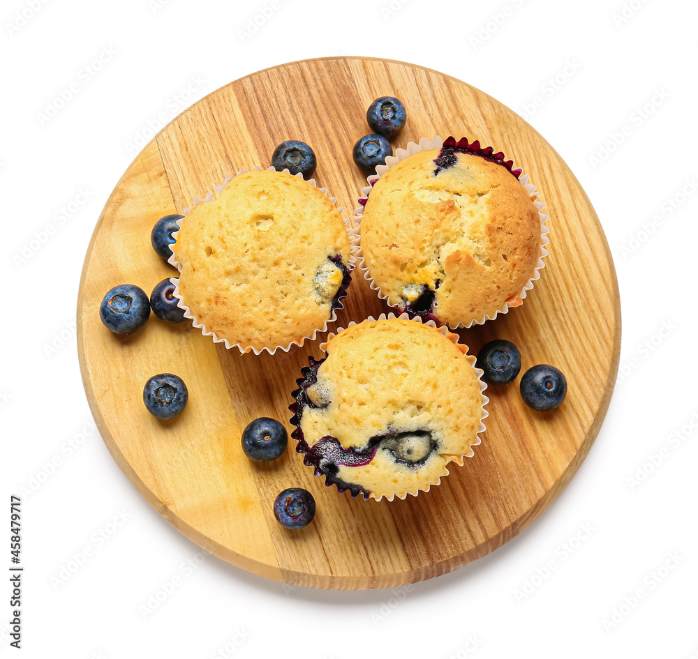Board with tasty blueberry muffins on white background