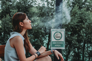 Asian woman inhaling and cigarette vaping. Female secretly smoking in bathroom at home. Concept of quit smoking and anti cigarette...