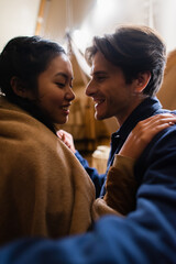 Wall Mural - Smiling multiethnic couple touching each other on glamping house terrace