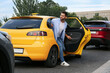 © New Africa - Handsome young man getting out of taxi on city street