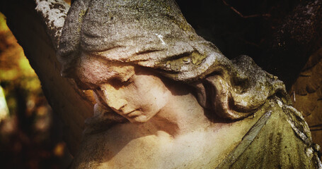 Fototapete - Ancient statue of an beautiful angel with dark background. Fragment. Horizontal image.