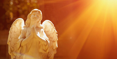 Wonderful angel in the rays of the sun (architecture, statue, archetype, religion, faith). Horizontal image.