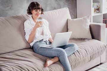 Sticker - Photo portrait woman wearing white shirt using computer typing message drinking coffee at home on couch