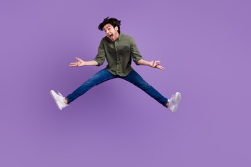 Poster - Full body photo of funky happy young man jumper up shrug shoulders enjoy isolated on purple color background