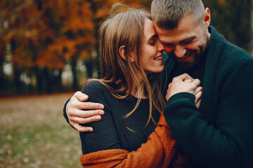 Elegant couple spend time in a autumn park