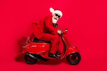 Poster - Photo of charming funky mature motorcyclist dressed christmas costume hat smiling hurrying isolated red color background