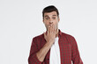 © Drobot Dean - Young handsome shocked european man covering mouth
