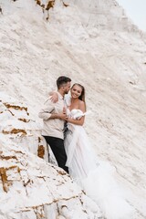 Wall Mural - Beautiful wedding couple bride and groom at wedding day outdoors at ocean beach. Happy marriage couple o