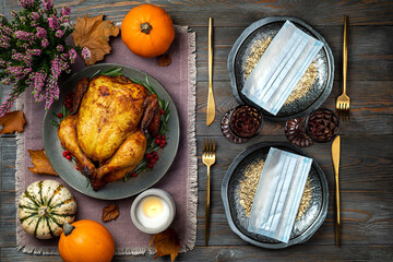 Wall Mural - Roasted chicken or turkey for Thanksgiving Day on festive table setting with protective mask on wooden table. Fried chicken, pumpkins for Thanksgiving dinner. Concept Thanksgiving in pandemic covid 19