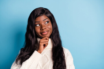 Sticker - Portrait of charming dark skin girl arm on chin look interested empty space isolated on blue color background