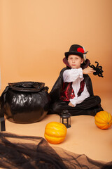 Wall Mural - a little evil vampire boy in a Count Dracula costume cooks a potion like a sorcerer on Halloween