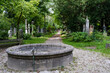 Historic antique old Südfriedhof graveyard cemetery with ancient tombstones, religious statues, trombs and graves in picturesque nature garden eden with lush wild garden eden vegetation and fountain