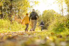 Parent And Child Walking In Autumn Park