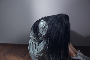 sad young woman sitting on the floor