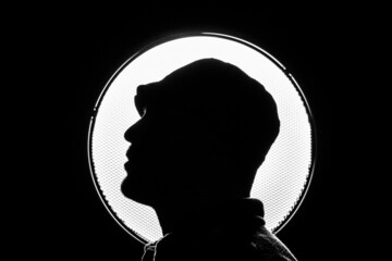 Sticker - Silhouette shot of a Caucasian man posing in front of a circular flashlight in Germany