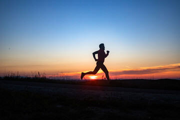 Wall Mural - active man silhouette running at sunset