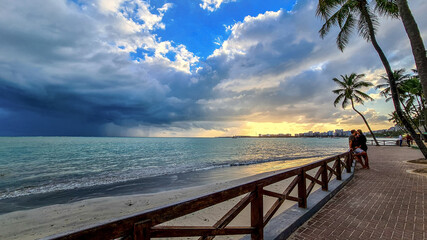 Sticker - Final de tarde na praia com nuvens e prédios