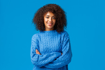 Wall Mural - Professionalism, employement and winter concept. Confident carefree good-looking african american girl with afro haircut, standing in sweater with crossed hands, smiling assertive and pleased