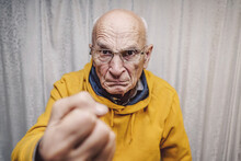 Portrait Of Angry Caucasian Man Wearing Eyeglasses And Showing Fist
