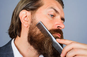 Sticker - Barbershop. Bearded man with comb. Professional beard care. Handsome male with barber tools. Closeup.