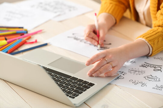 Young female calligraphist working in office