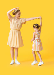 Sticker - Dancing young woman and her little daughter on color background